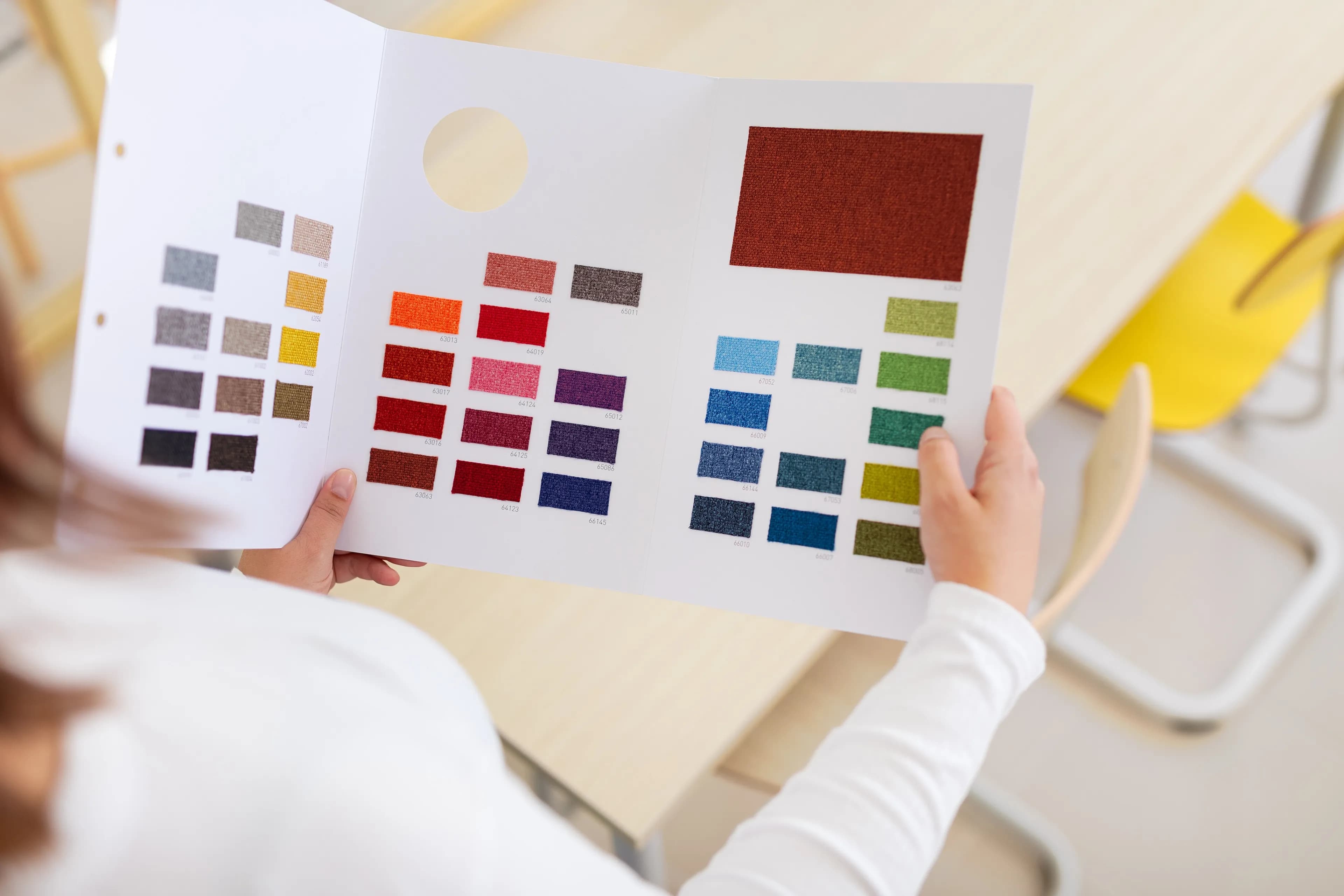 Image of a person holding fabric samples.
